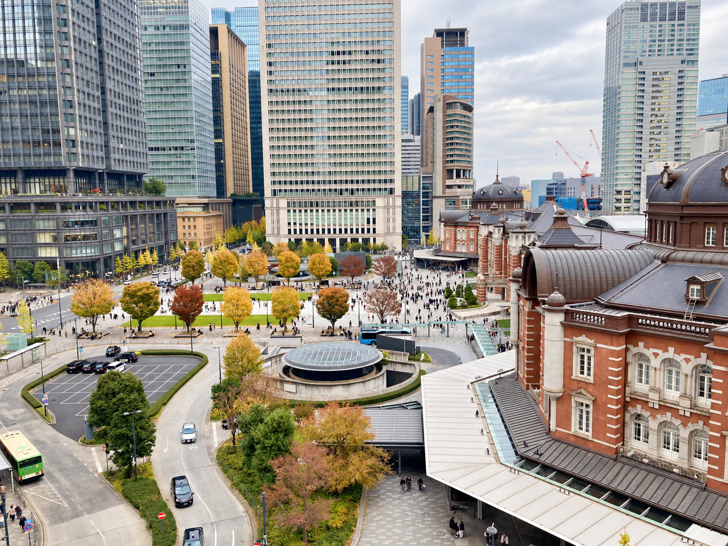 The historic façade of Tokyo Station and the modern buildings of Marunouchi.